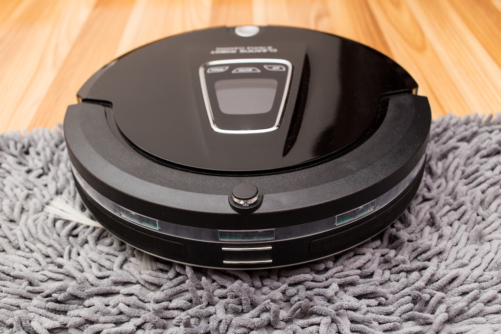 Robotic vacuum cleaner on wood parquet floor